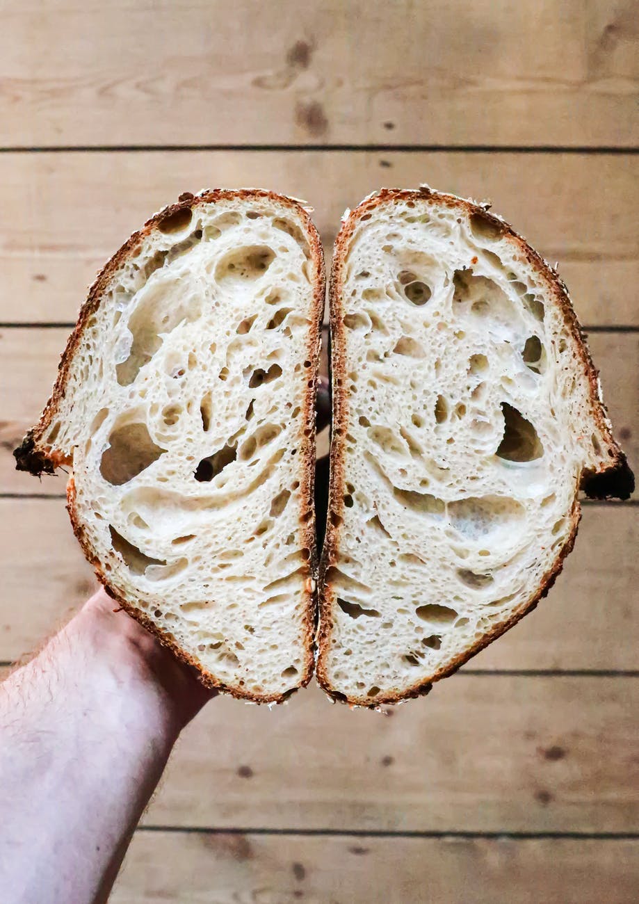 crop unrecognizable person showing yummy cut bread
